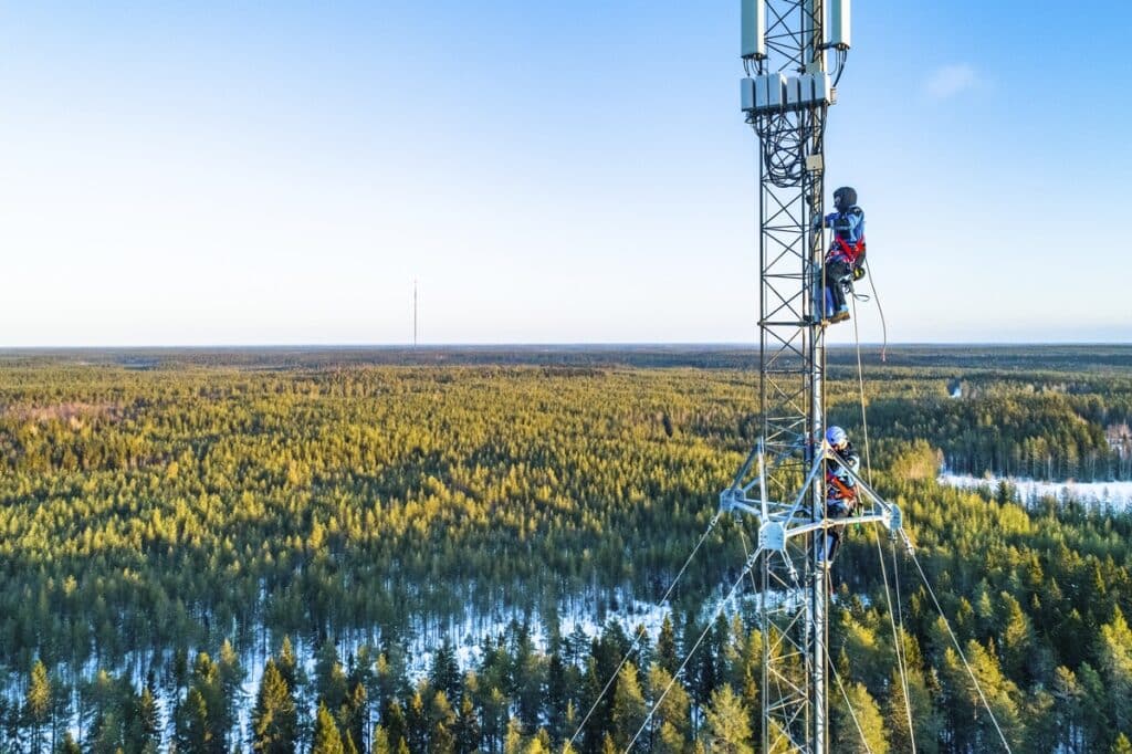 Henkilöitä työskentelemässä tietoliikennemastossa.