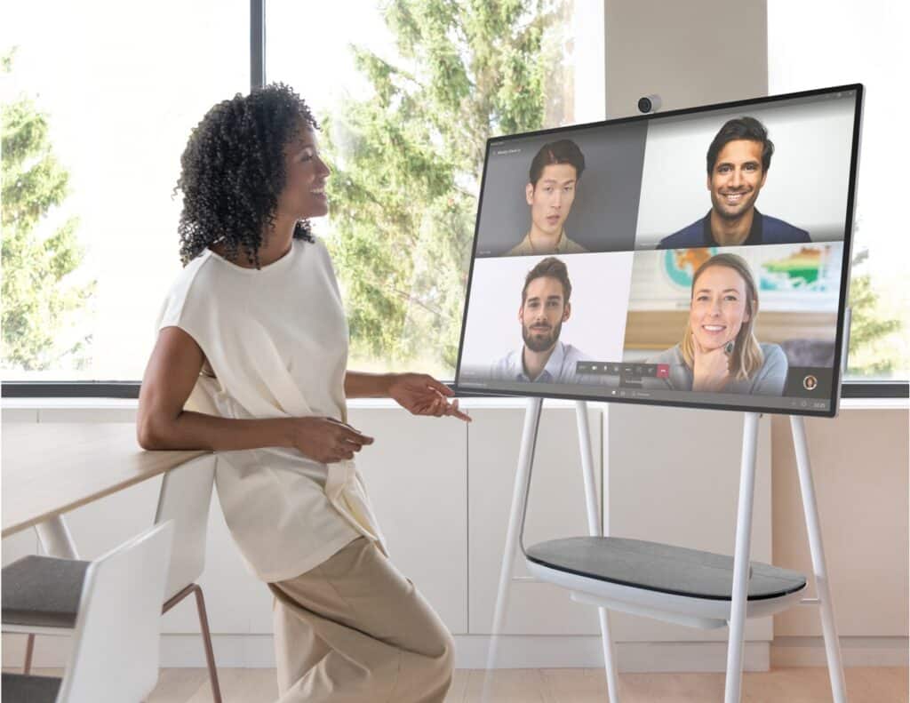 Henkilö seisoo Microsoft Surface Hub 2S -näytön äärellä ja osallistuu videokokoukseen.